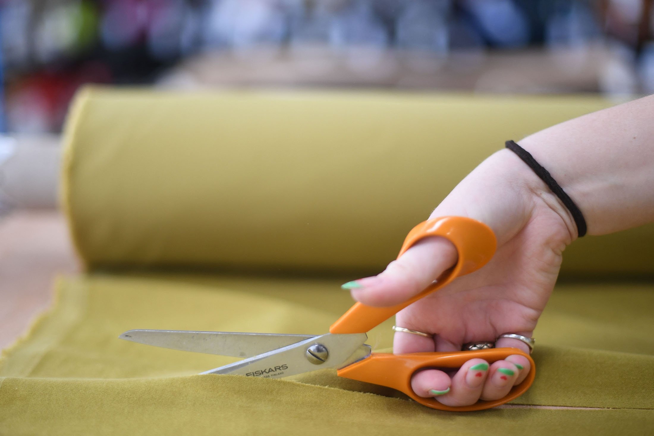 Molly cuts a piece of fabric for an online order at The New Craft House, a sewing workshop studio and designer deadstock fabric shop, in Hackney, East London, U.K., Feb. 11, 2022. (AFP Photo)