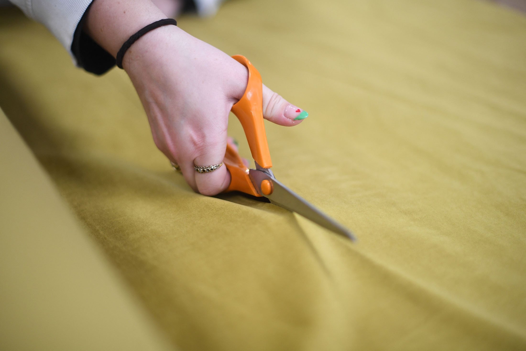Molly cuts a piece of fabric for an online order at The New Craft House, a sewing workshop studio and designer deadstock fabric shop, in Hackney, East London, U.K., Feb. 11, 2022. (AFP Photo)