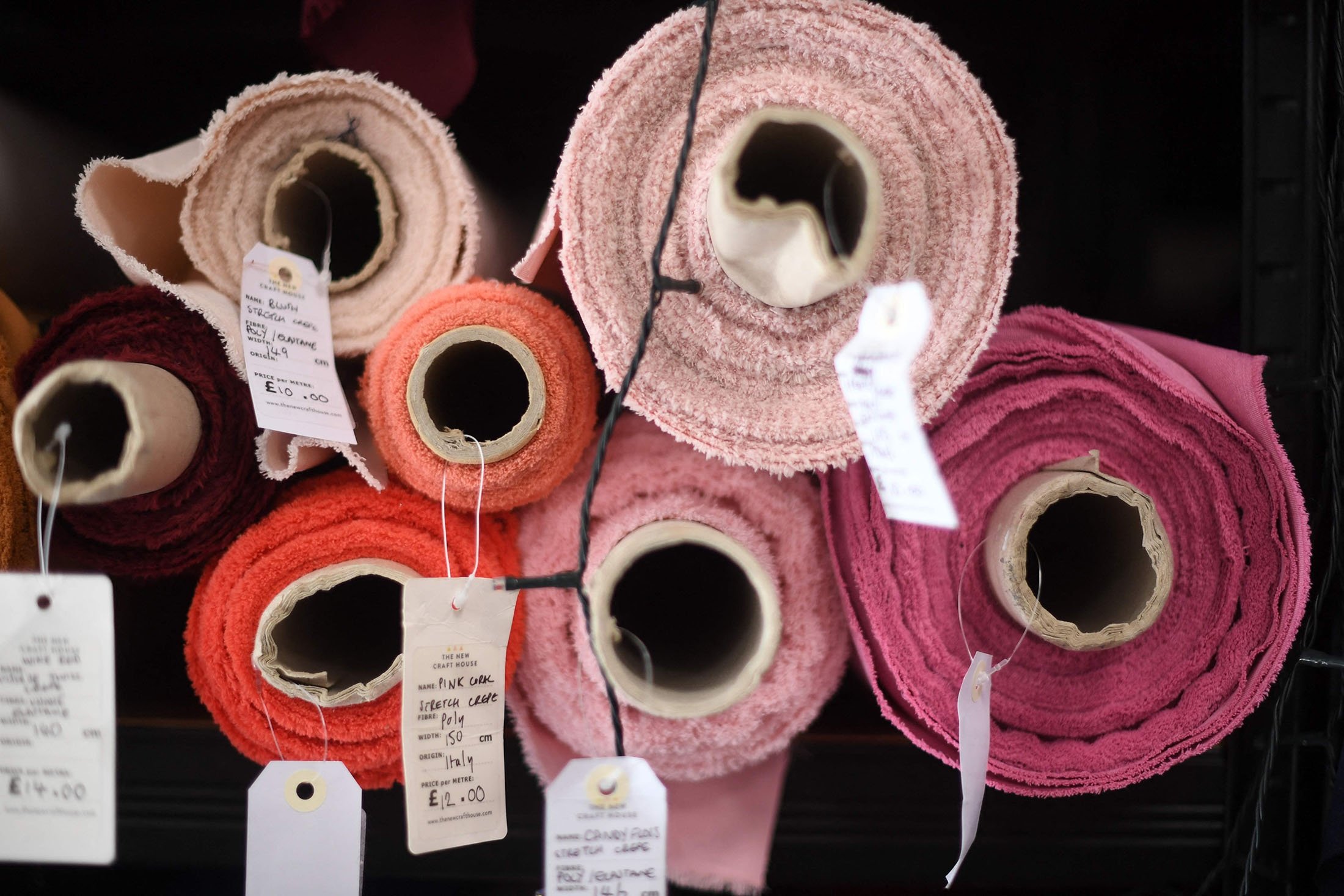 Fabric rolls and their labels displayed at The New Craft House, a sewing workshop studio and designer deadstock fabric shop, in Hackney, East London, U.K., Feb. 11, 2022. (AFP Photo)