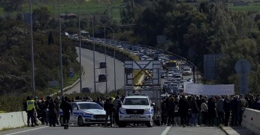 Area residents block a motorway near a refugee camp to protest what they say are the various problems that have arisen as a result of an overflowing migrant reception center near their community, Nicosia, Greek Cyprus, Feb. 20, 2022. (AP Photo)