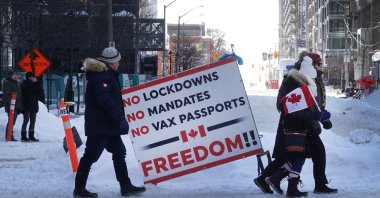 People walk toward Parliament Hill where earlier in the day police moved in and ended a demonstration organized by truck drivers opposing vaccine mandates that had been entrenched for the past 23 days in Ottawa, Ontario, Canada, Feb. 19, 2022. (AFP Photo)