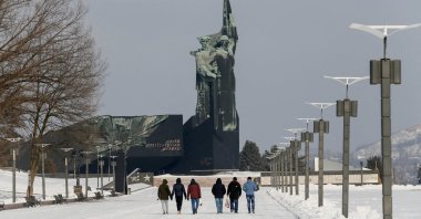People walk towards a monument to the Liberators of Donbass in the rebel-held city of Donetsk, Ukraine, Jan. 27, 2022. (Reuters File Photo)