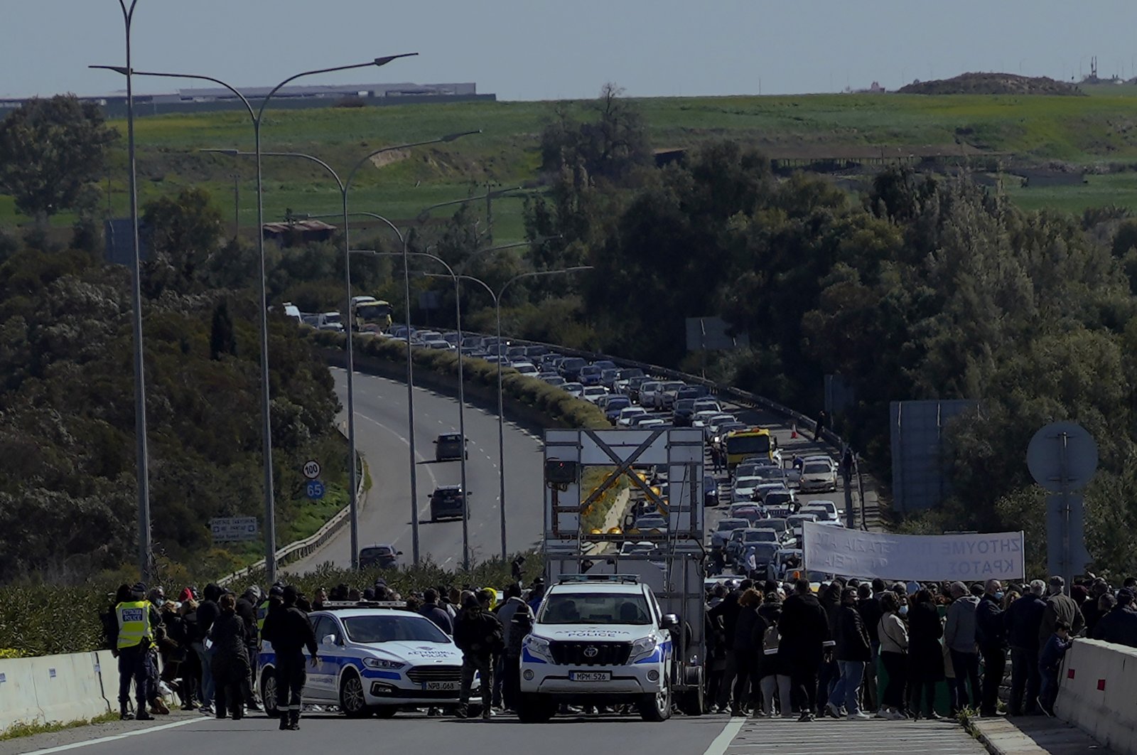 Area residents block a motorway near a refugee camp to protest what they say are the various problems that have arisen as a result of an overflowing migrant reception center near their community, Nicosia, Greek Cyprus, Feb. 20, 2022. (AP Photo)