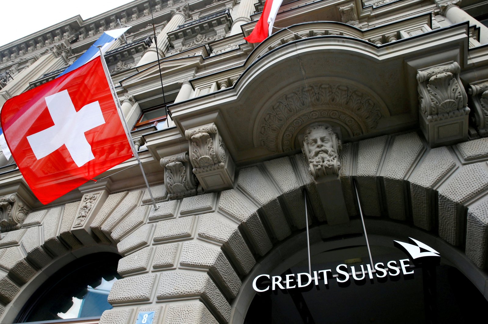 Switzerland&#039;s national flag flies below a logo of Swiss bank Credit Suisse at its headquarters at the Paradeplatz Square in Zurich, Switzerland, July 31, 2019. (Reuters Photo)
