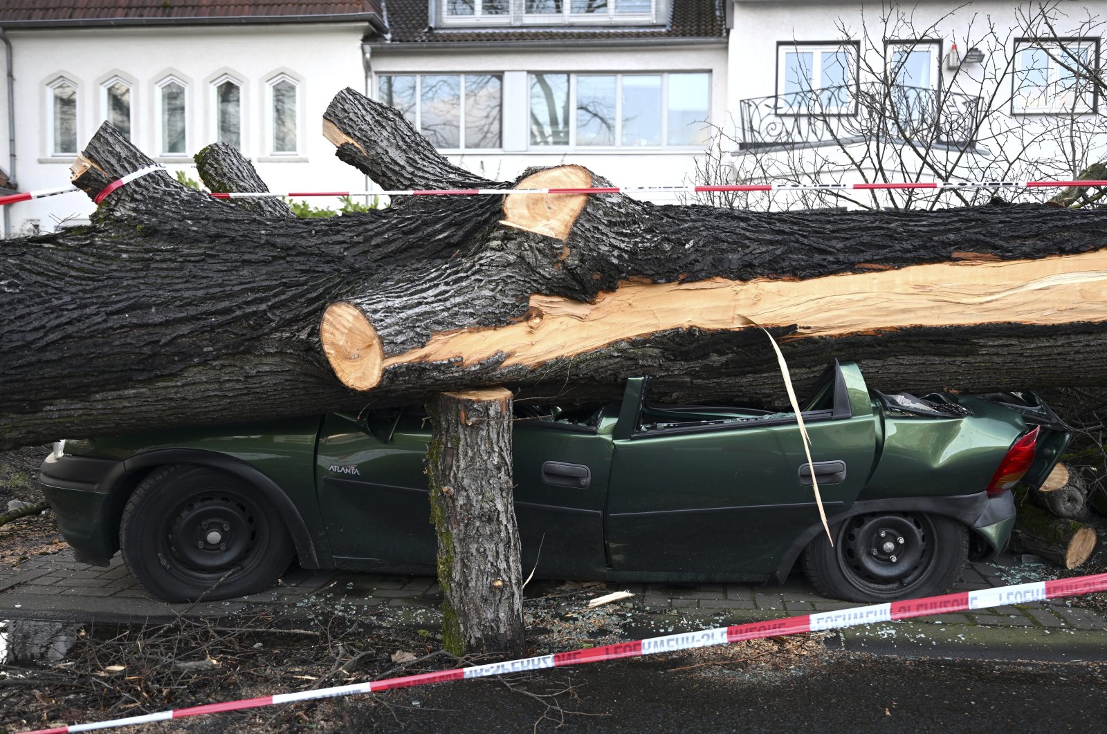 A car is destroyed by a fallen tree in Cologne, Germany, Feb. 21, 2022. (AP Photo)