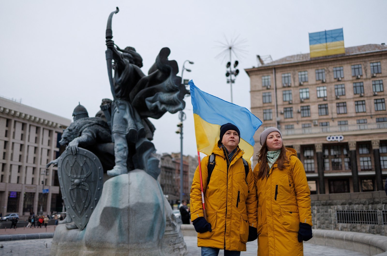A couple hold the national flag during a rally near the monument to the so-called &quot;Heavenly Hundred&quot;, the people killed in Maidan uprising, the Ukrainian pro-European Union (EU) mass protests that toppled President Yanukovich in 2014, in central Kyiv, Ukraine February 20, 2022. (Reuters File Photo)
