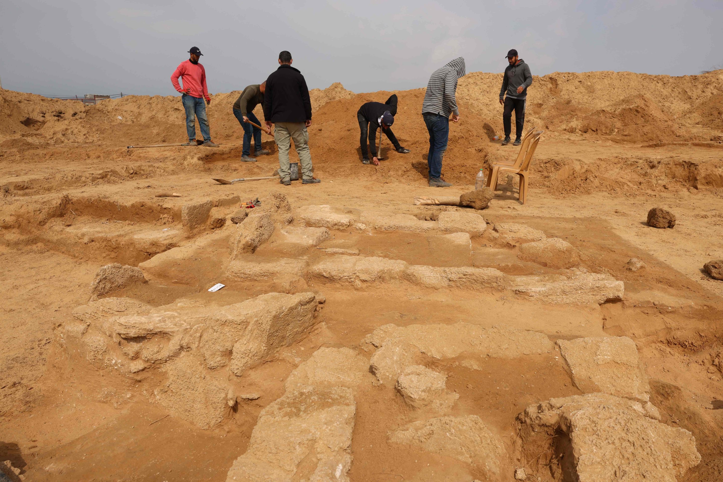 Palestinian workers excavate a newly discovered Roman cemetery containing ornately decorated graves, in Beit Lahia in the northern Gaza Strip, Feb. 20, 2022. (AFP)
