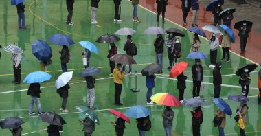 Residents line up to get tested for the coronavirus at a temporary testing center despite the rain in Hong Kong, Feb. 22, 2022. (AP Photo)