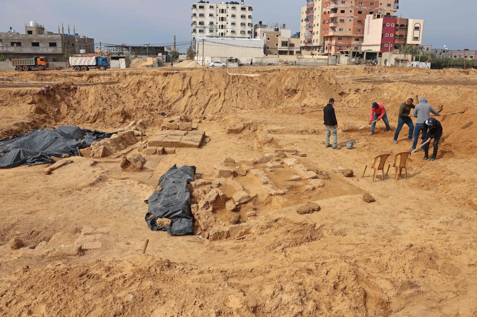 Palestinian workers excavate a newly discovered Roman cemetery containing ornately decorated graves, in Beit Lahia in the northern Gaza Strip, on Feb. 20, 2022. (AFP)