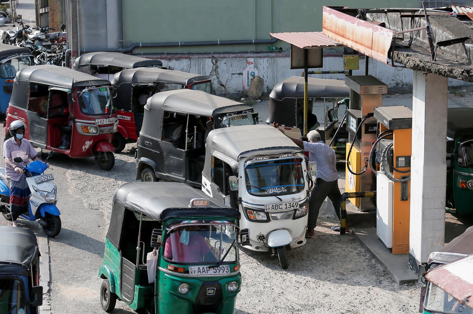 Three-wheeler drivers wait in line to top up their tanks at a Ceylon Petroleum Corporation fuel station in Colombo, Sri Lanka, Feb. 21, 2022. (Reuters Photo)