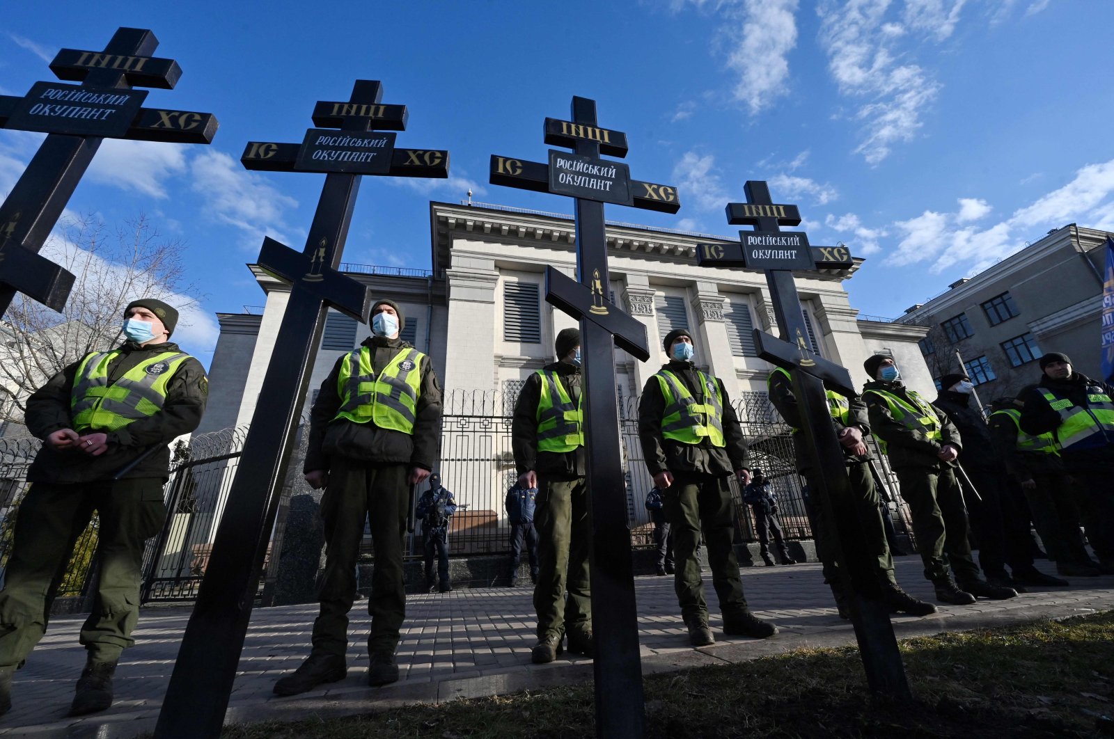 Ukrainian National Guard servicemen stay in guard after activists set symbolic tomb crosses with the inscription &quot;Russian occupier&quot; during the rally called  &quot;Empire must die&quot; outside the Russian Embassy in Kyiv, Ukraine, Feb. 22, 2022. (AFP Photo)
