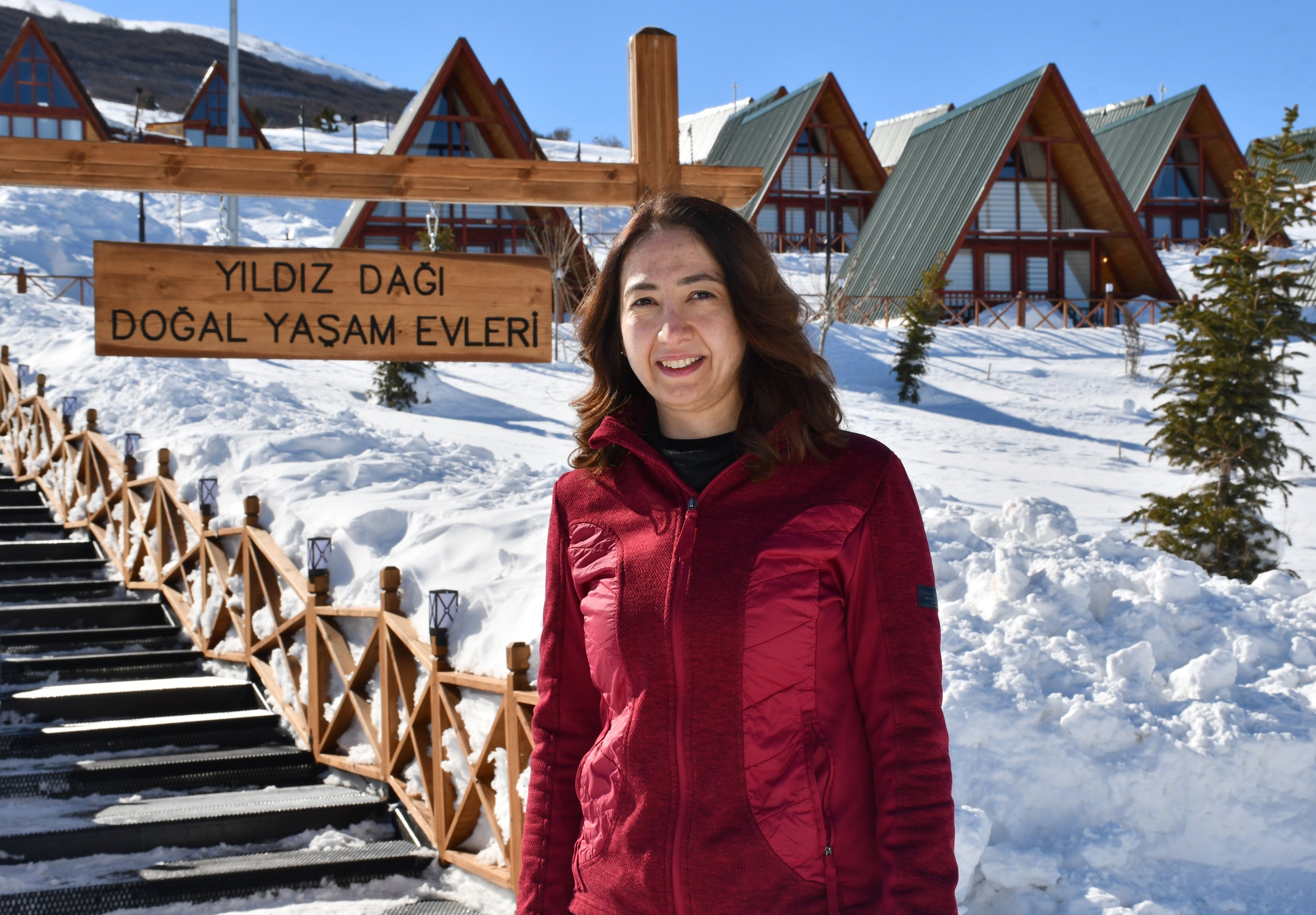 An avid fan of the facility, Çiğdem Budak poses outside the self-contained bungalows at Sivas' Yıldız Mountain Winter Sports and Tourism Center, Sivas, central Turkey, Feb. 22, 2022. (AA Photo)