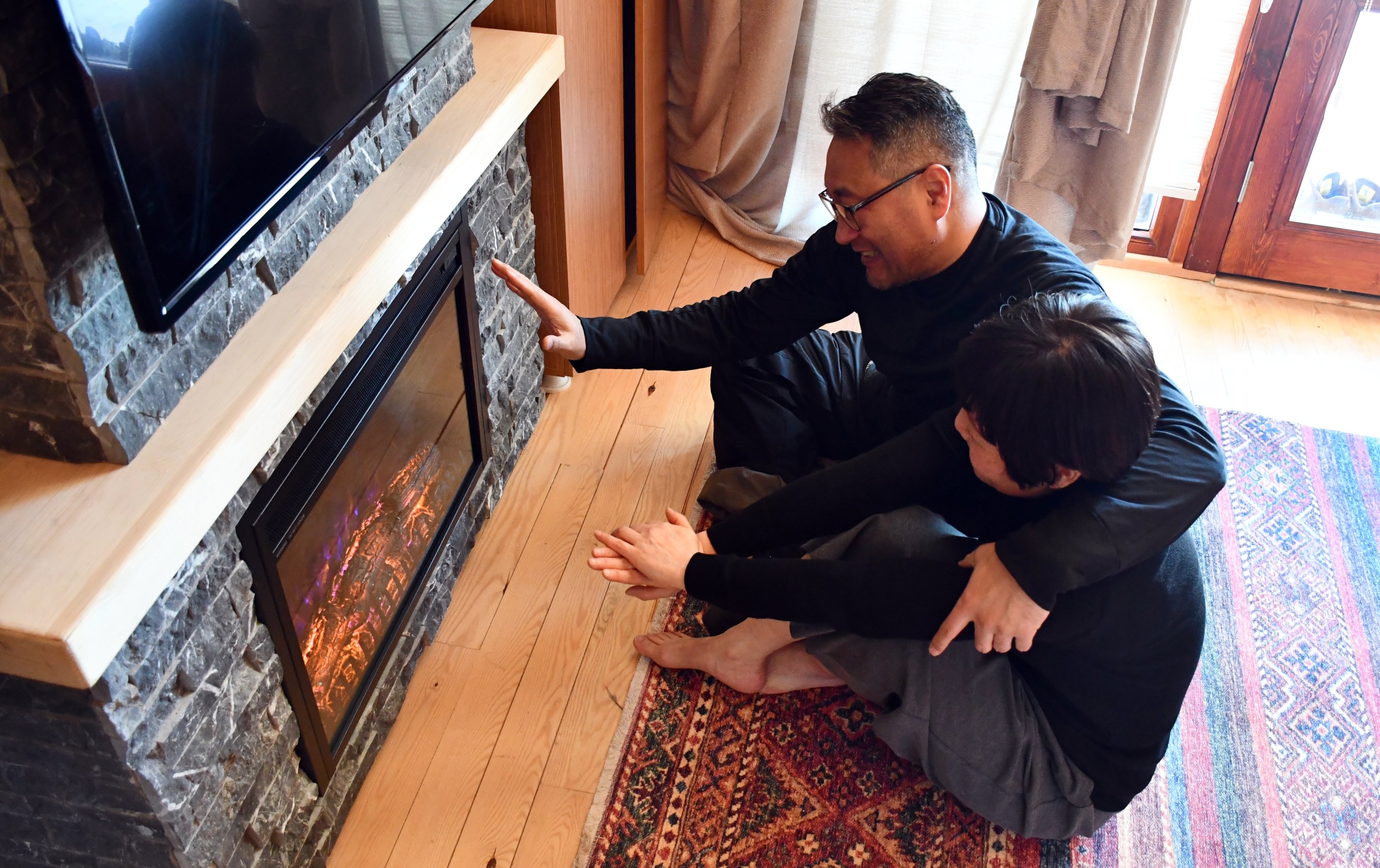 South Korean guest Back Myoungsu and his family guest sit in front of the fireplace in one of the self-contained bungalows at the Yıldız Mountain Winter Sports and Tourism Center, Sivas, central Turkey, Feb. 22, 2022. (AA Photo)