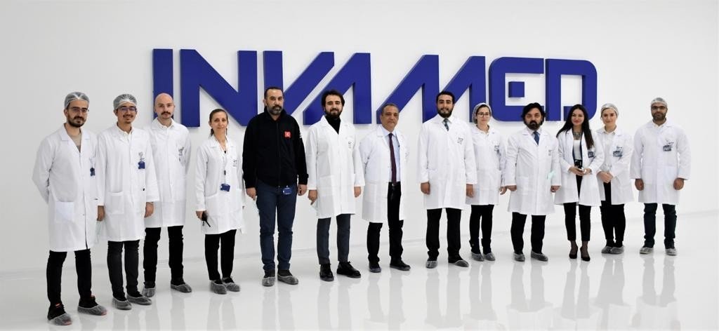 The team of Turkish biotech company INVAMED-RD Global are seen in front of the company logo, Feb. 22, 2022. (AA Photo)