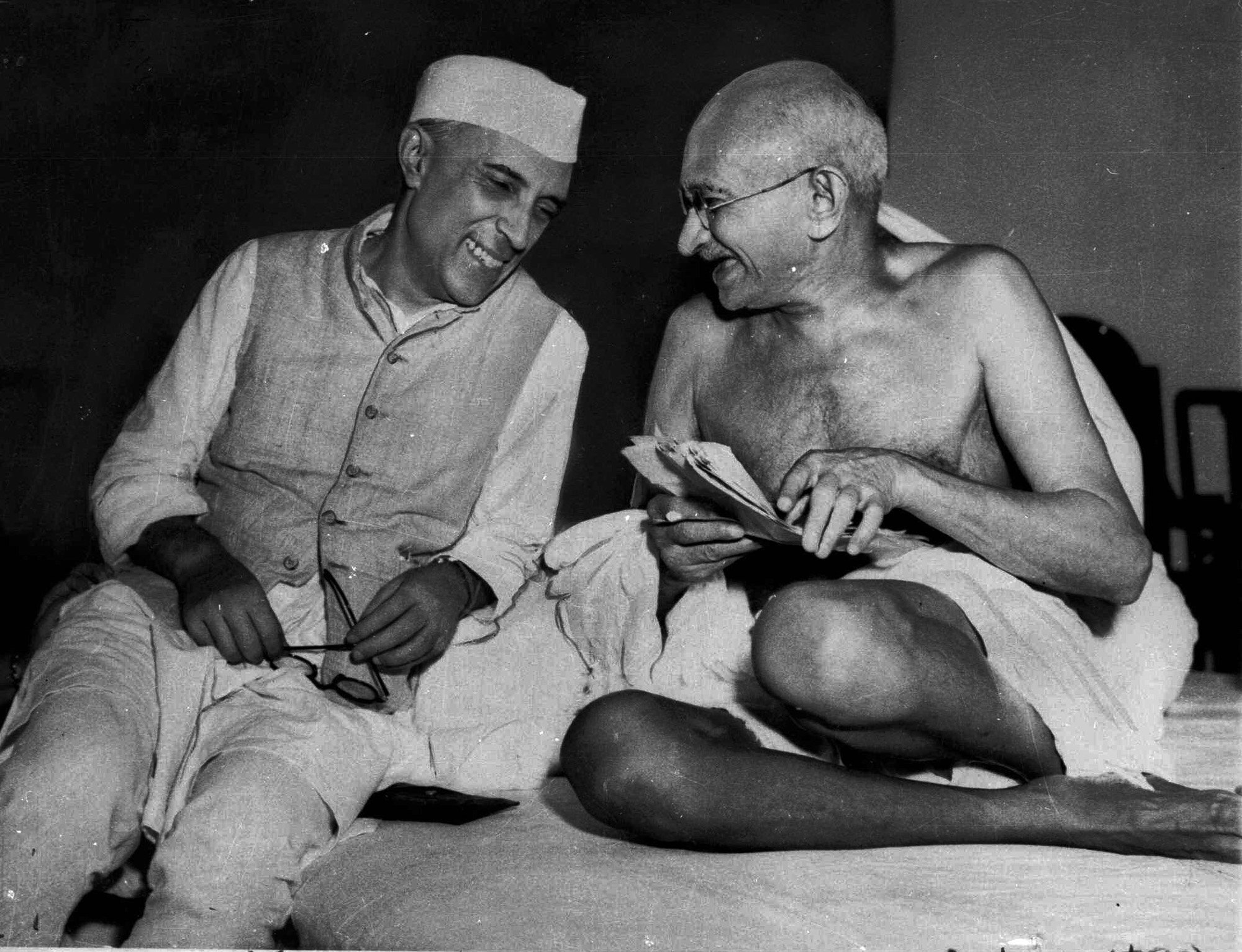 A bespectacled Mohandas Gandhi, the Mahatma, who eventually led India to its independence, laughs with the man who was to be the nation's first prime minister, Jawaharlal Nehru, at the All-India Congress committee meeting in Bombay, India, on July 6, 1946. (AP) 