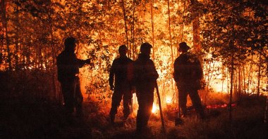 Firefighters work at the scene of a forest fire near Kyuyorelyakh village at Gorny Ulus area, west of Yakutsk, in Russia, Aug. 5, 2021. (AP Photo)