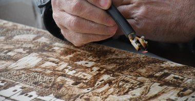 Yılmaz Öngün etching a piece at his workshop, Aksaray, central Turkey, Feb. 20, 2022. (IHA Photo)