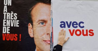 LREM and "Les Jeunes avec Macron" (JAM) supporters stick posters asking for French President Emmanuel Macron's candidacy to the French presidential election, in Issy-les-Moulineaux, near Paris, on Feb.18, 2022. (AFP Photo)