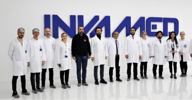 The team of Turkish biotech company INVAMED-RD Global are seen in front of the company logo, Feb. 22, 2022. (AA Photo)