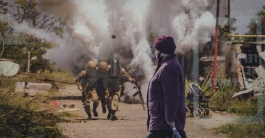 A woman walks by a photographic memorial for those killed in the confrontation between Ukraine's military and the pro-Russia separatist forces in Sievierodonetsk, Luhansk region, eastern Ukraine, Feb. 23, 2022. (AP Photo)