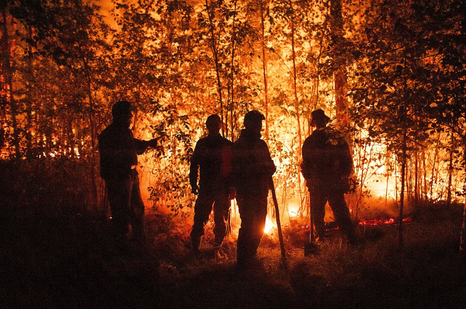 Firefighters work at the scene of a forest fire near Kyuyorelyakh village at Gorny Ulus area, west of Yakutsk, in Russia, Aug. 5, 2021. (AP Photo)