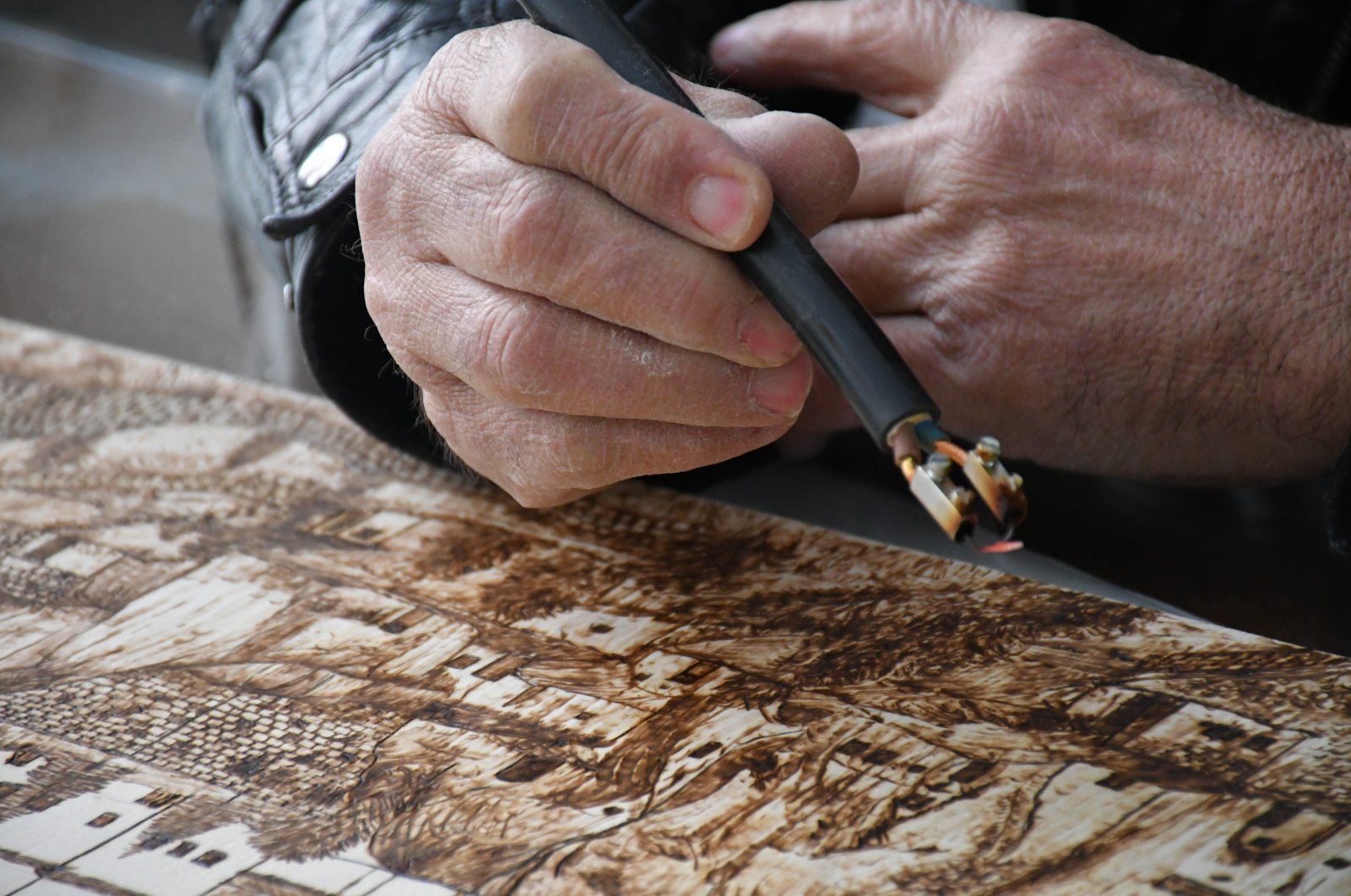 Yılmaz Öngün etching a piece at his workshop, Aksaray, central Turkey, Feb. 20, 2022. (IHA Photo)