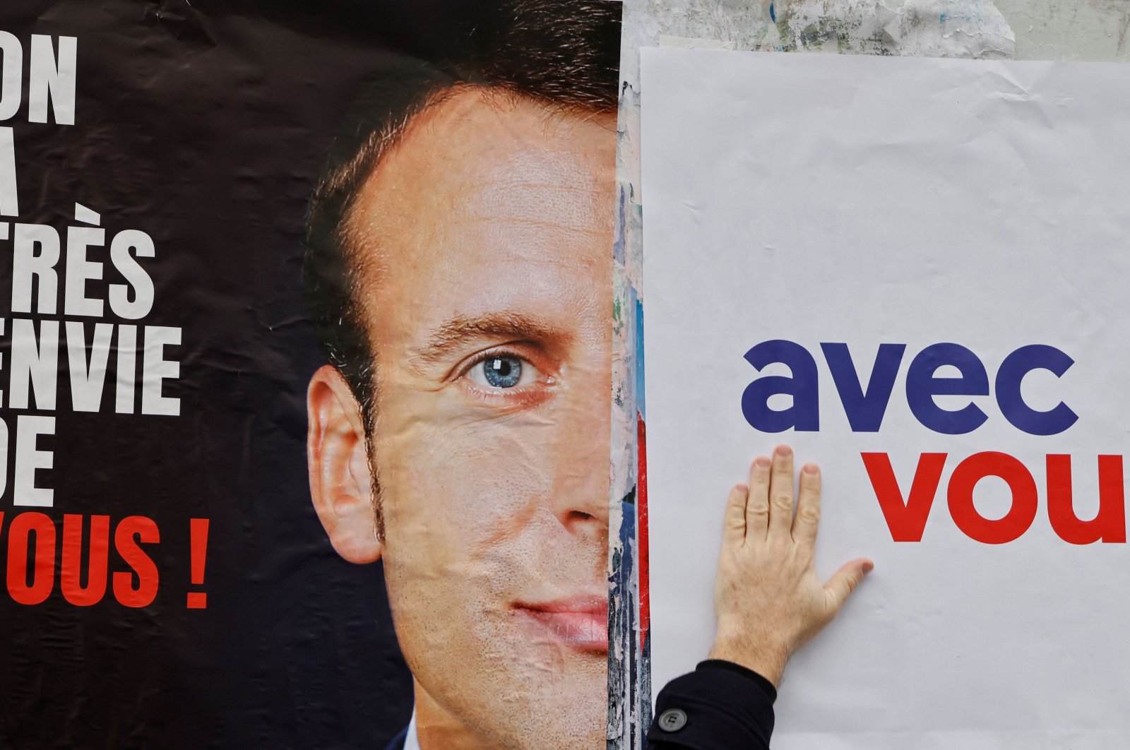 LREM and "Les Jeunes avec Macron" (JAM) supporters stick posters asking for French President Emmanuel Macron&#039;s candidacy to the French presidential election, in Issy-les-Moulineaux, near Paris, on Feb.18, 2022. (AFP Photo)