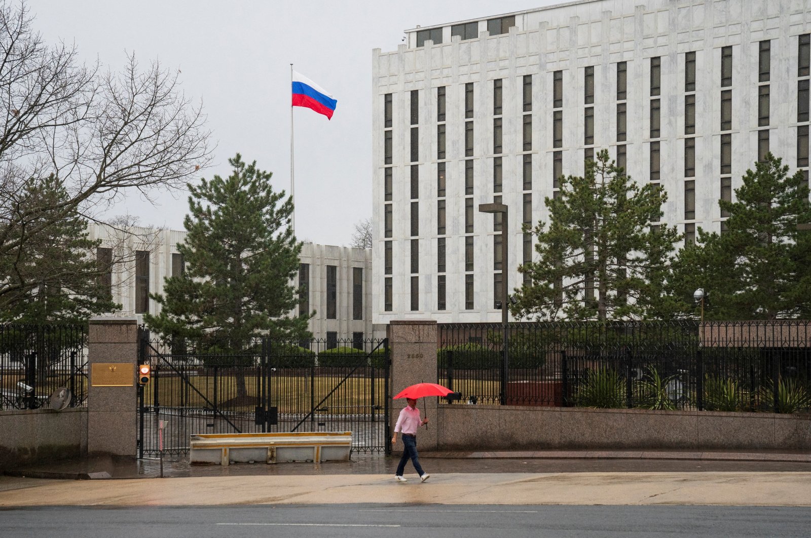 A pedestrian walks with an umbrella outside the Embassy of the Russian Federation, near the Glover Park neighborhood of Washington, D.C., U.S., Feb. 22, 2022. (Reuters Photo)