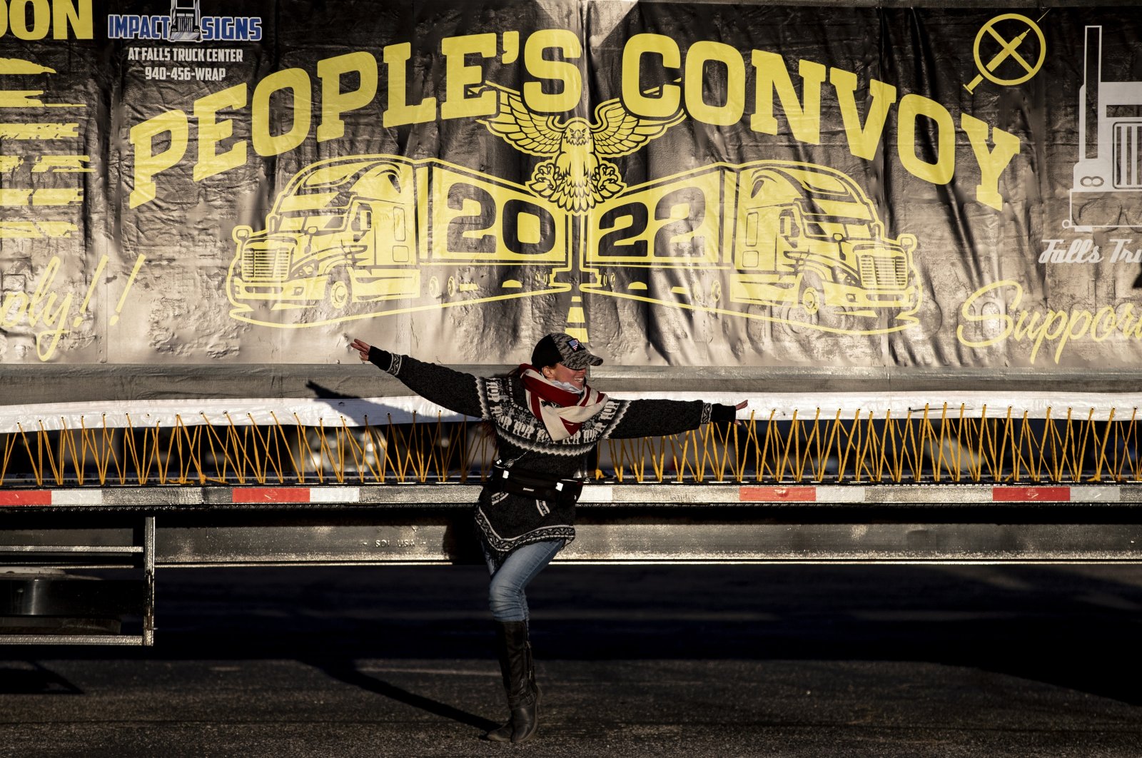 A supporter poses under a truck-mounted banner reading "People&#039;s Convoy" during the gathering ahead of its departure, at the Adelanto Stadium, Adelanto, California, U.S., Feb. 22, 2022. (EPA Photo)
