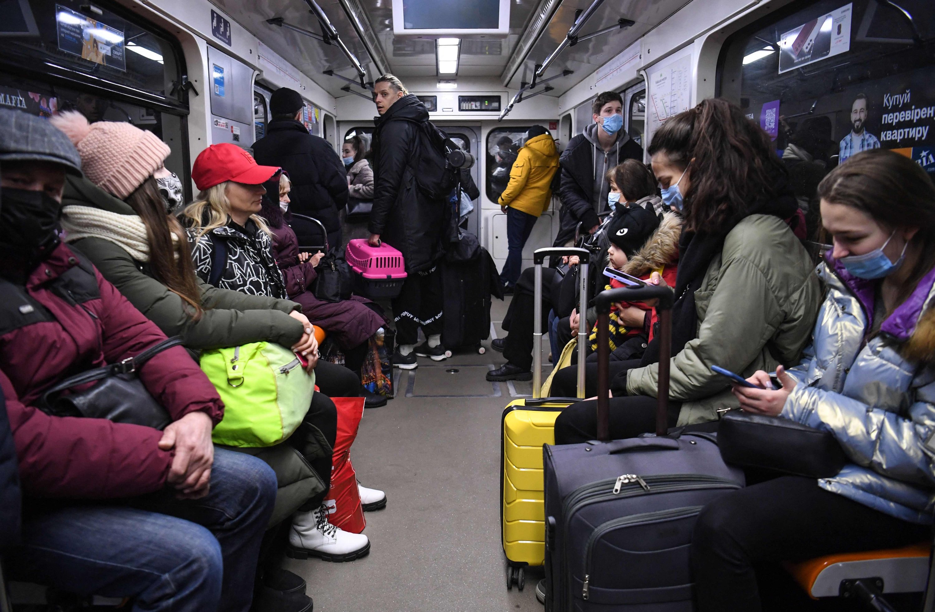 People, some carrying bags and suitcases, sit in a metro in Kyiv, Ukraine, on the morning of Feb. 24, 2022. (AFP Photo)