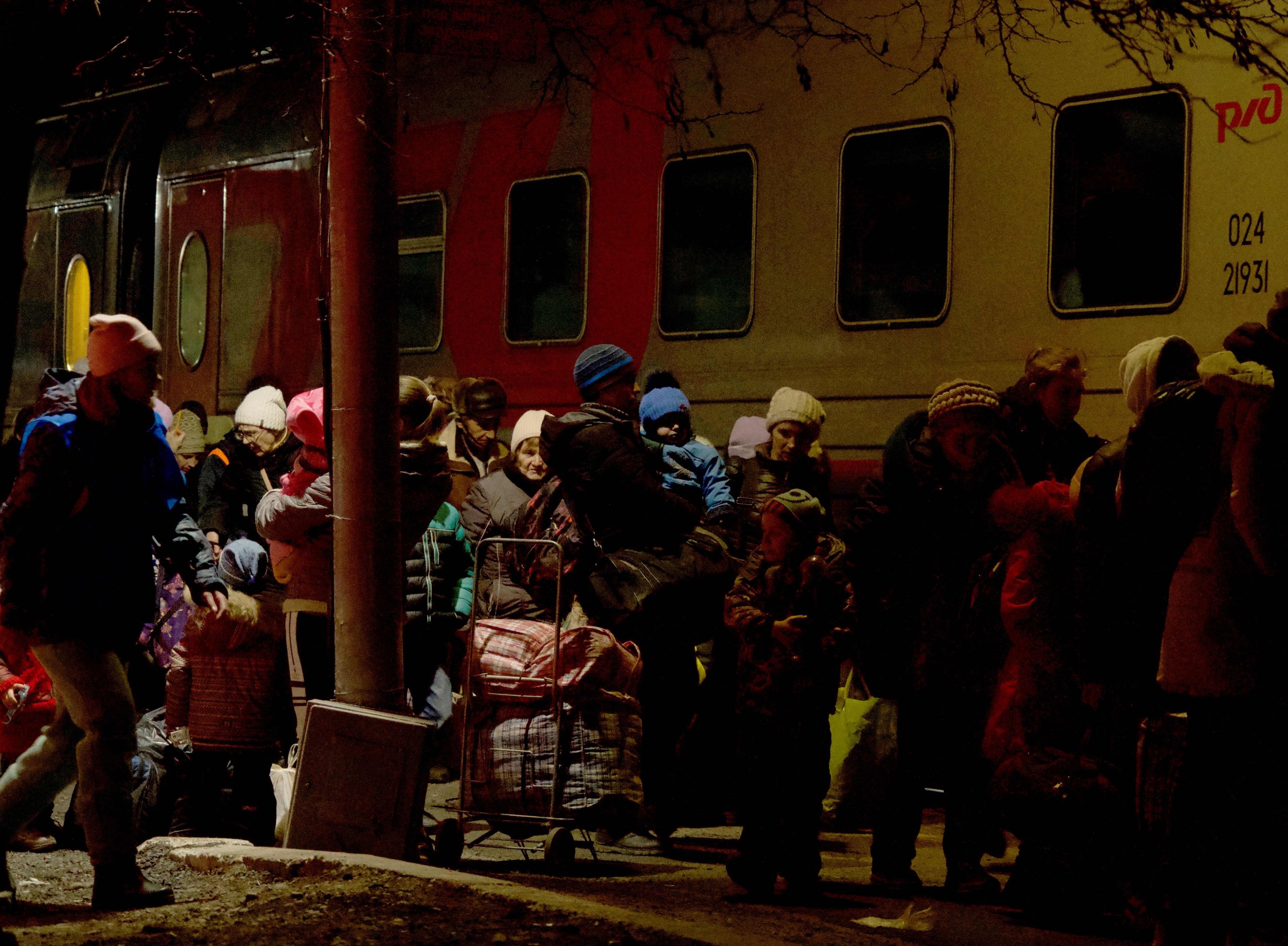 People evacuated from the self-proclaimed Donetsk People's Republic queue outside a train before their evacuation deep into Russia, in the town of Taganrog, Feb. 20, 2022. (AFP Photo)