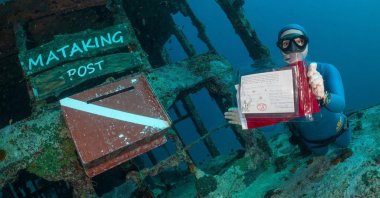 Turkish diver Şahika Ercümen holds a postcard for President Recep Tayyip Erdoğan and first lady Emine Erdoğan at an undersea postbox, Sabah, Malaysia, Feb. 23, 2022. (AA Photo)