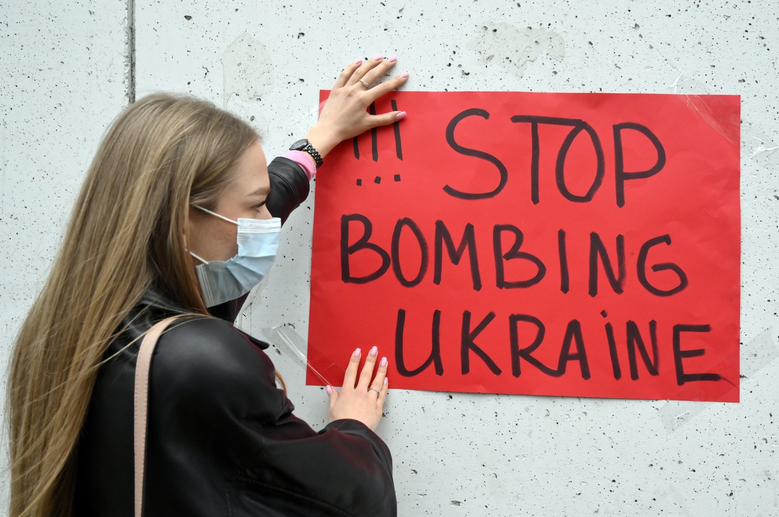An Ukrainian woman who lives in Lebanon hangs a placard on a wall during a protest outside the Russian embassy in Beirut, Lebanon, 24 February 2022. (EPA File Photo)