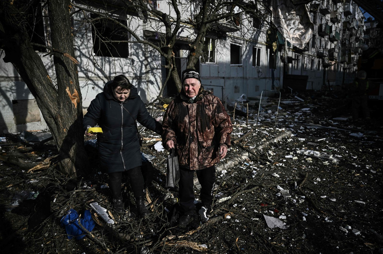 People walk outside a destroyed building after bombings on the eastern Ukraine town of Chuguiv, Feb. 24, 2022. (AFP Photo)
