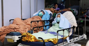 A 98-year-old patient who tested positive for the omicron variant of COVID-19, lies on a hospital bed outside the emergency ward of Caritas Medical Center in Hong Kong, China, Feb. 17, 2022. (Reuters Photo)