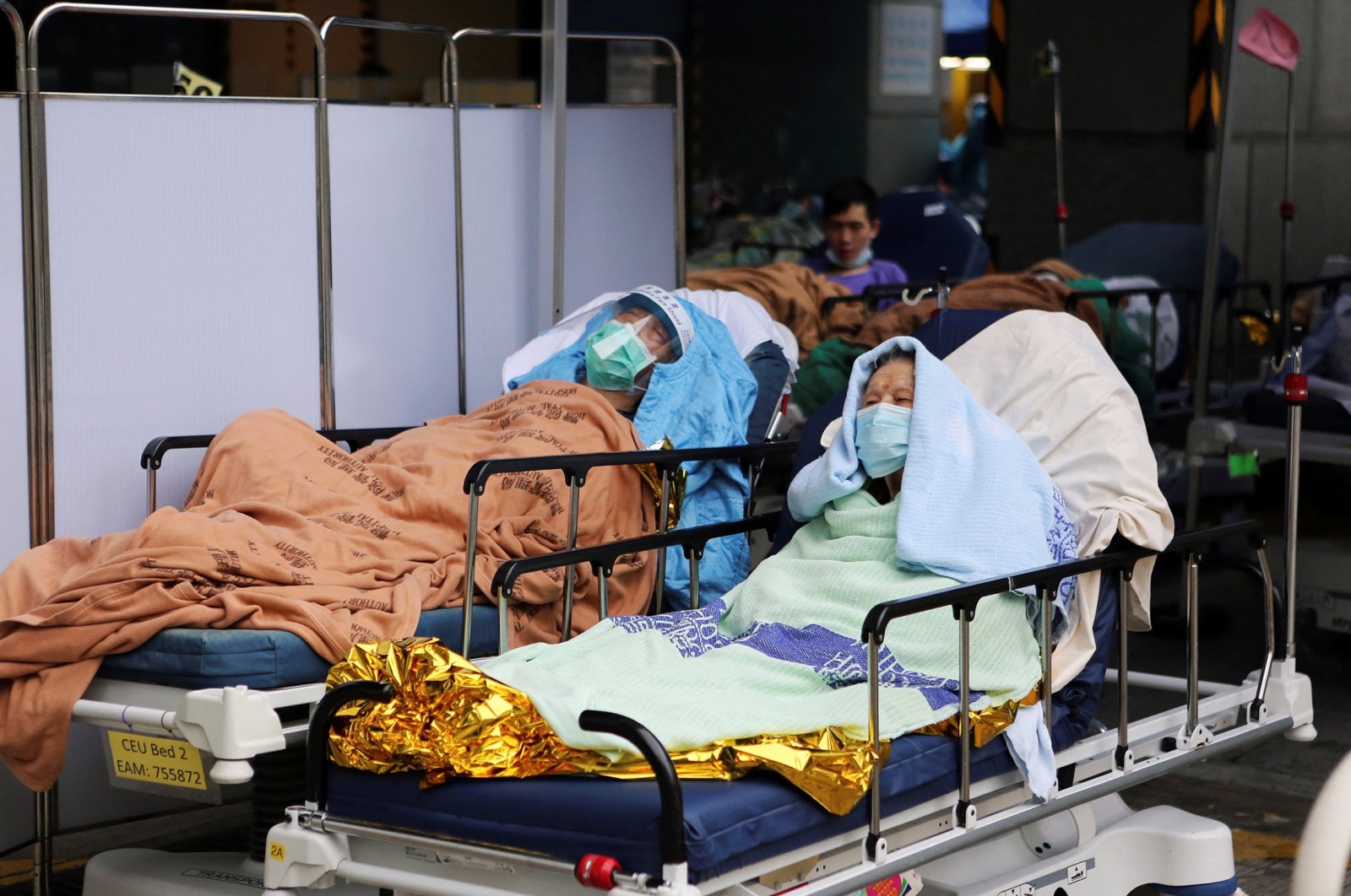 A 98-year-old patient who tested positive for the omicron variant of COVID-19, lies on a hospital bed outside the emergency ward of Caritas Medical Center in Hong Kong, China, Feb. 17, 2022. (Reuters Photo)