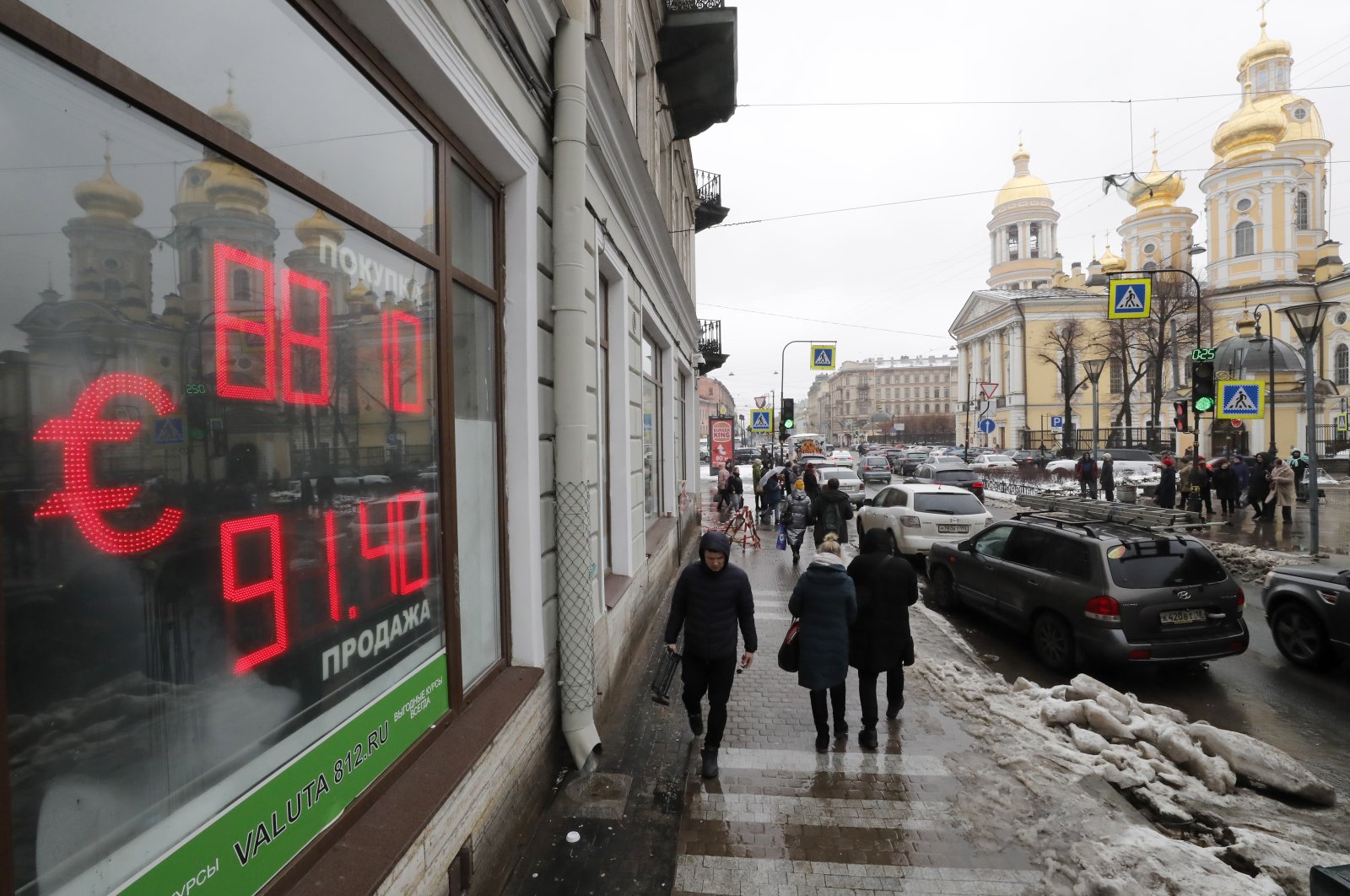 People walk in front of an electronic panel displaying the euro currency rate at an exchange office in St. Petersburg, Russia, Feb. 22, 2022. (EPA Photo)