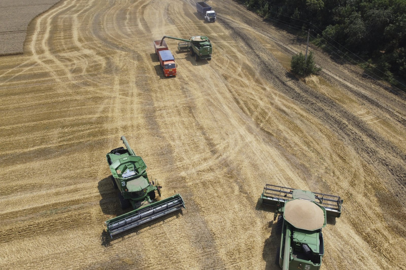 Farmers harvest a wheat field with their combines near the village Tbilisskaya, Russia, July 21, 2021. (AP Photo)