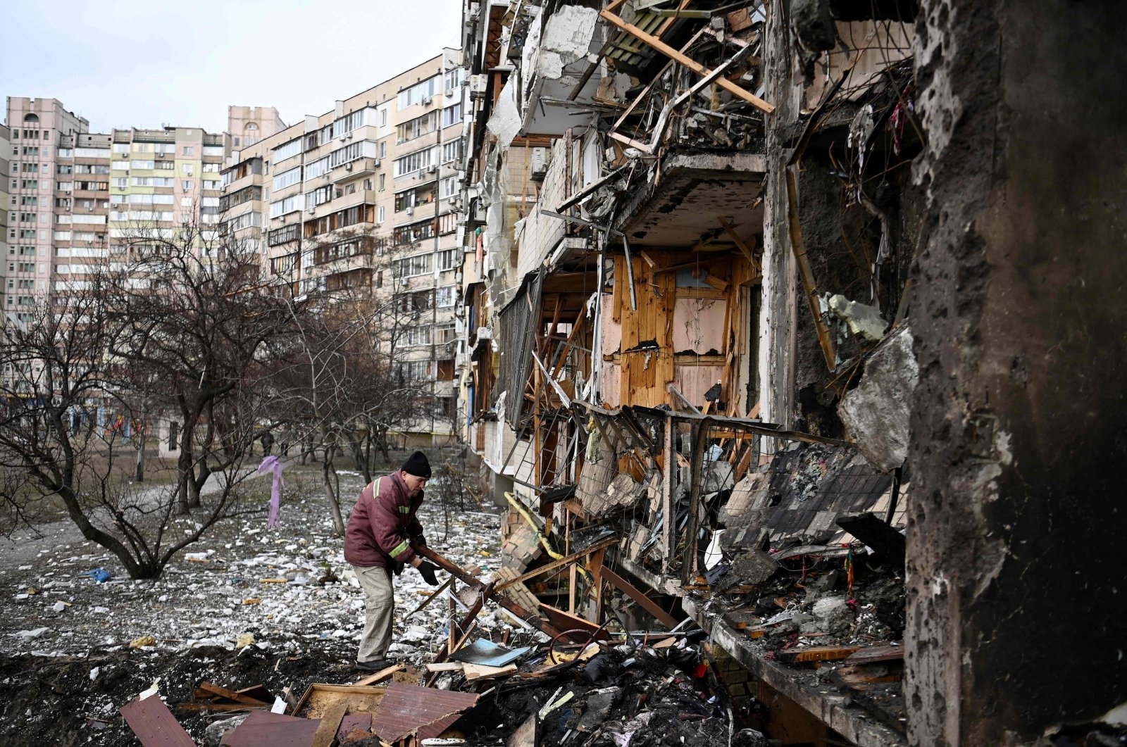A man clears debris at a damaged residential building at Koshytsa Street, a suburb of the Ukrainian capital Kyiv, where a military shell allegedly hit, Feb.25, 2022. (AFP Photo)