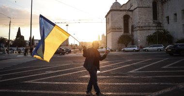 A man holds a Ukraine flag as he takes part in the Human Cordon for Peace in Ukraine, in Lisbon, Portugal, Feb. 26, 2022. (EPA Photo)