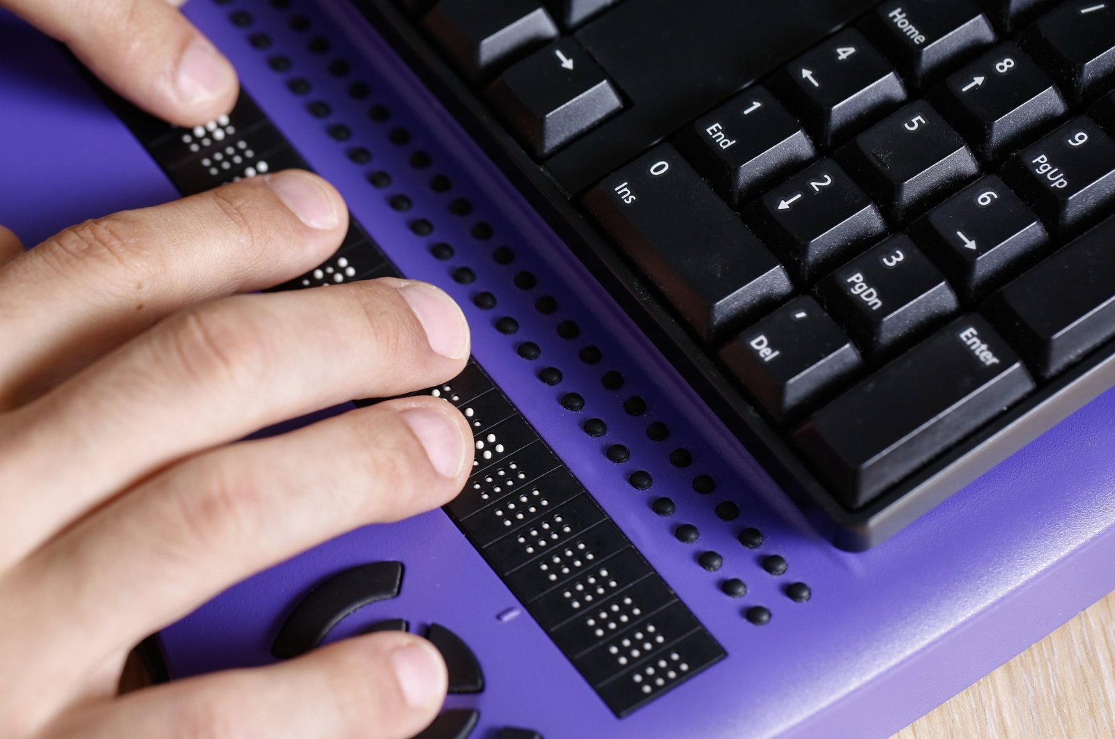A visually impaired person using a computer with a braille keyboard is shown in this undated photo. (Shutterstock Photo)
