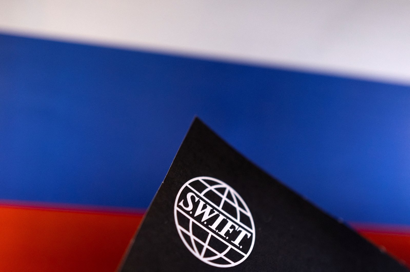 SWIFT logo is placed on a Russian flag are seen in this illustration taken, Bosnia-Herzegovina, Feb. 25, 2022. (Reuters Photo)