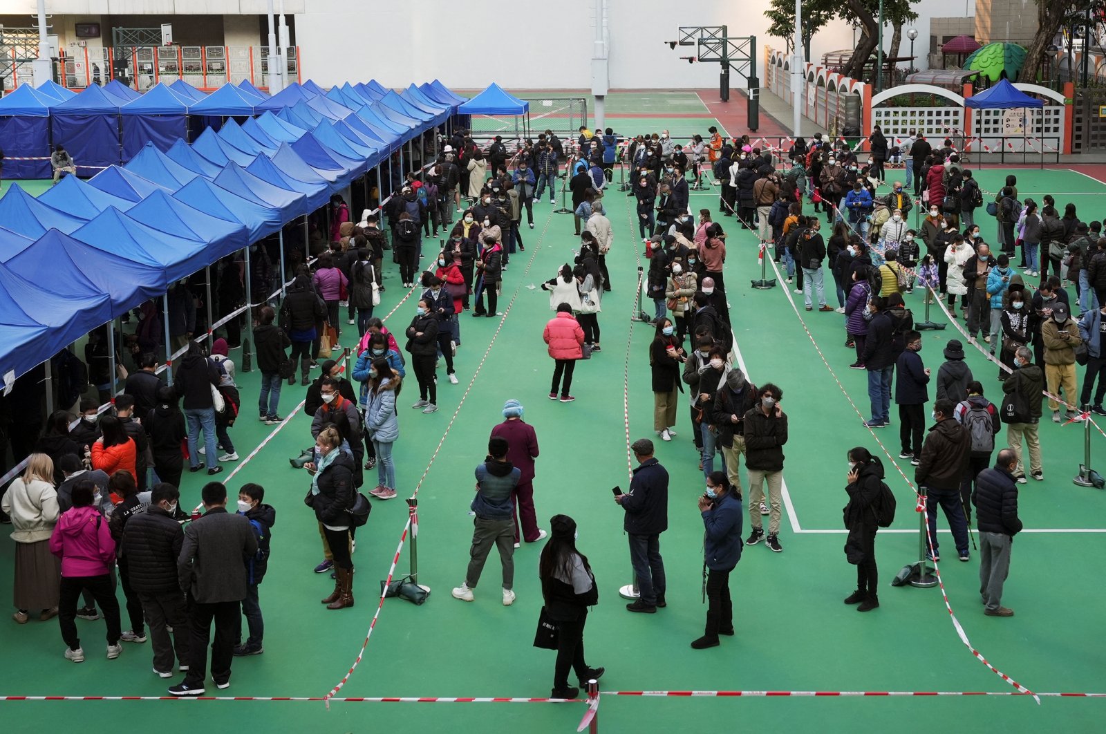 People wearing face masks line up at a testing center for COVID-19 in Hong Kong, China, Feb. 23, 2022. (Reuters Photo)