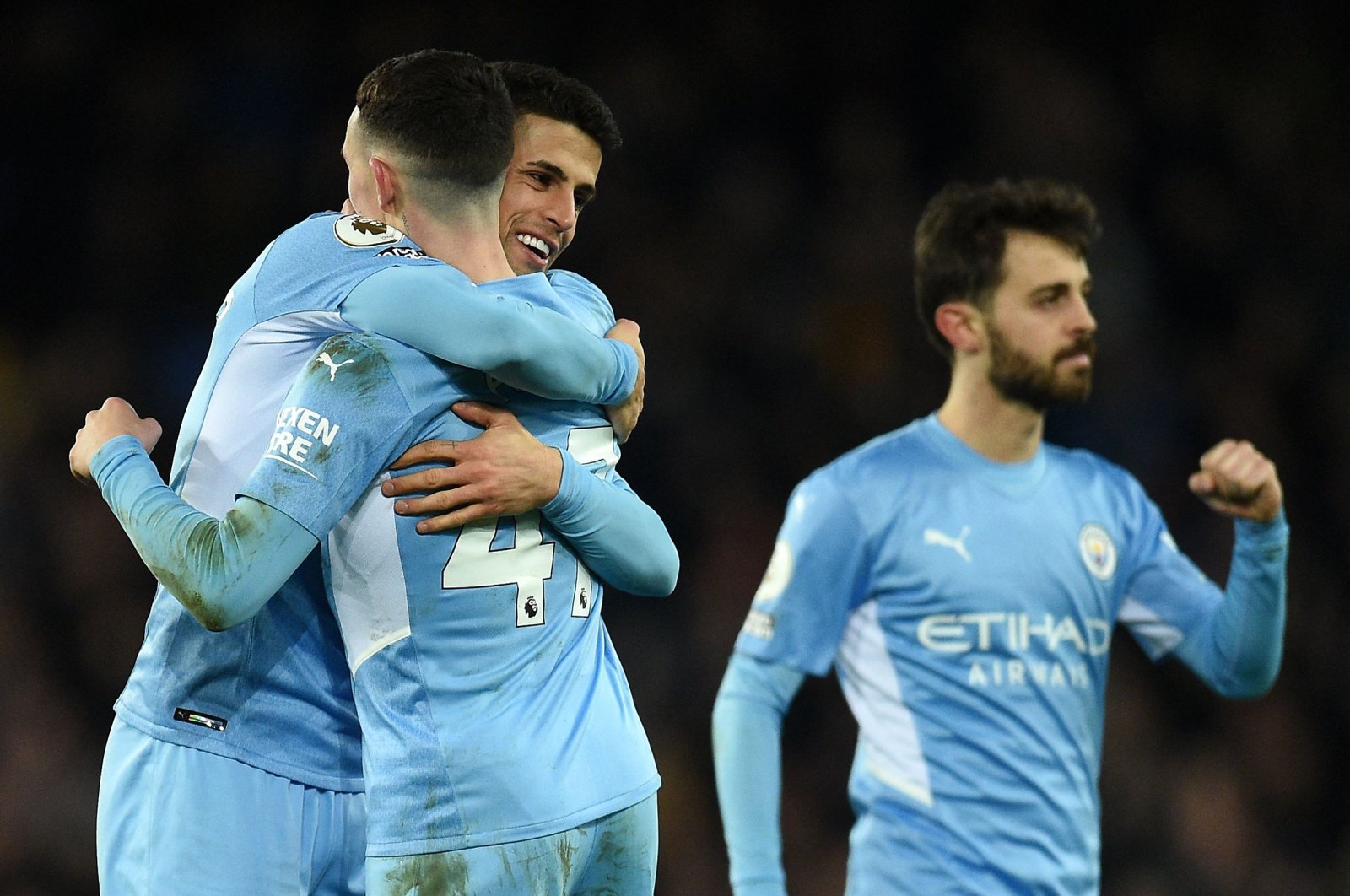 Manchester City's Joao Cancelo (L), Phil Foden (C) and Bernardo Silva (R) celebrate after winning a Premier League match against Everton, Liverpool, England, Feb. 26, 2022. (AFP Photo)