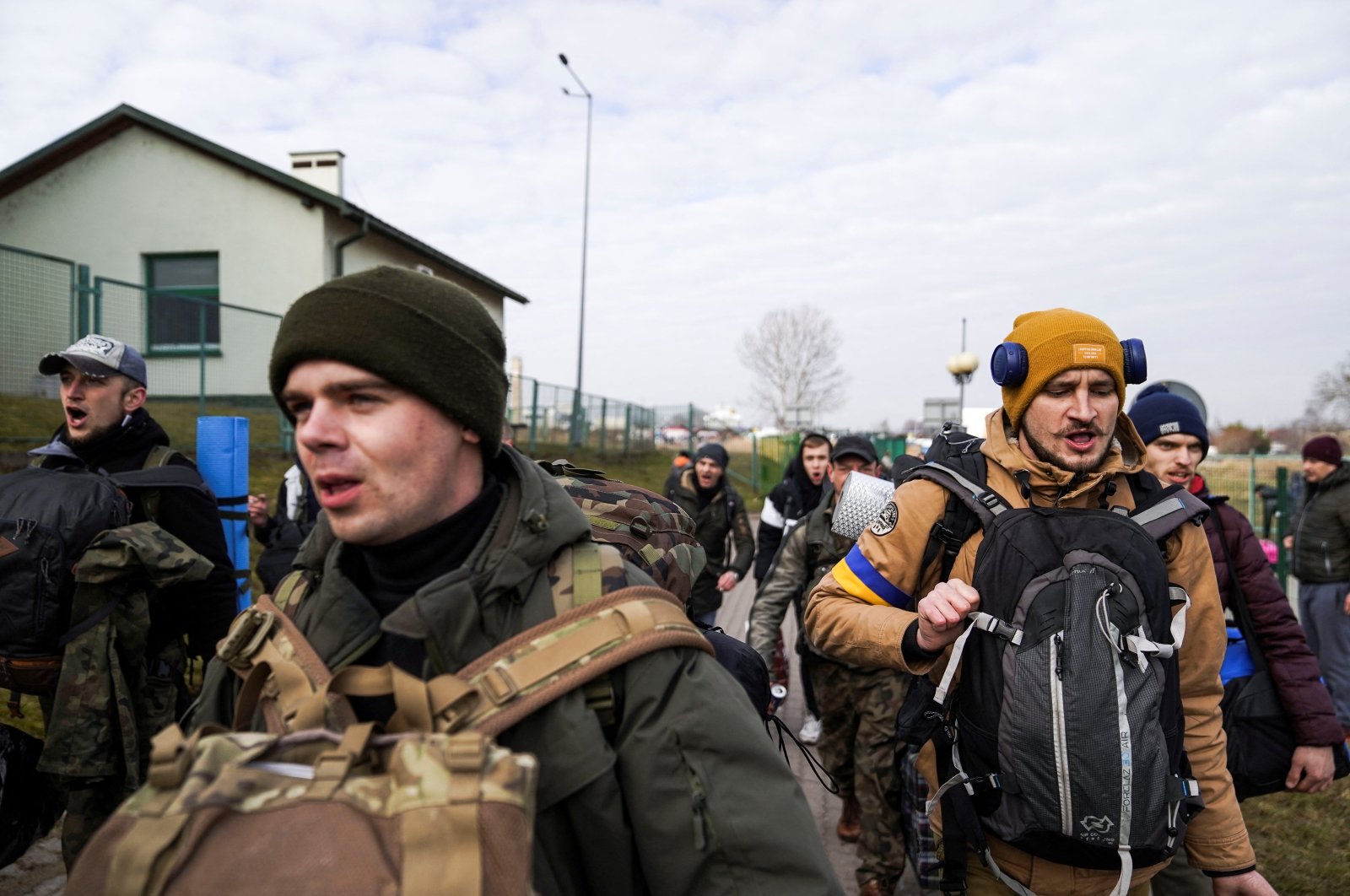 A group of Ukrainian men, returning to Ukraine to help defend against the Russian invasion, enter the border crossing, in Medyka, Poland, Feb. 27, 2022. (Reuters Photo)