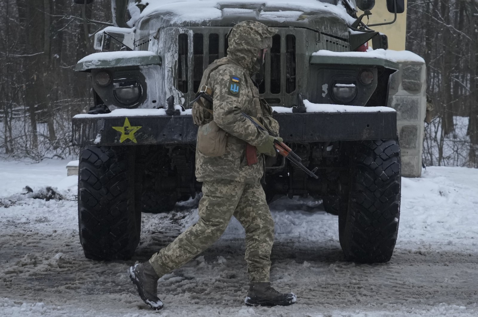 A Ukrainian serviceman walks by a deactivated Russian military multiple rocket launcher on the outskirts of Kharkiv, Ukraine, Feb. 25, 2022. (AP Photo)