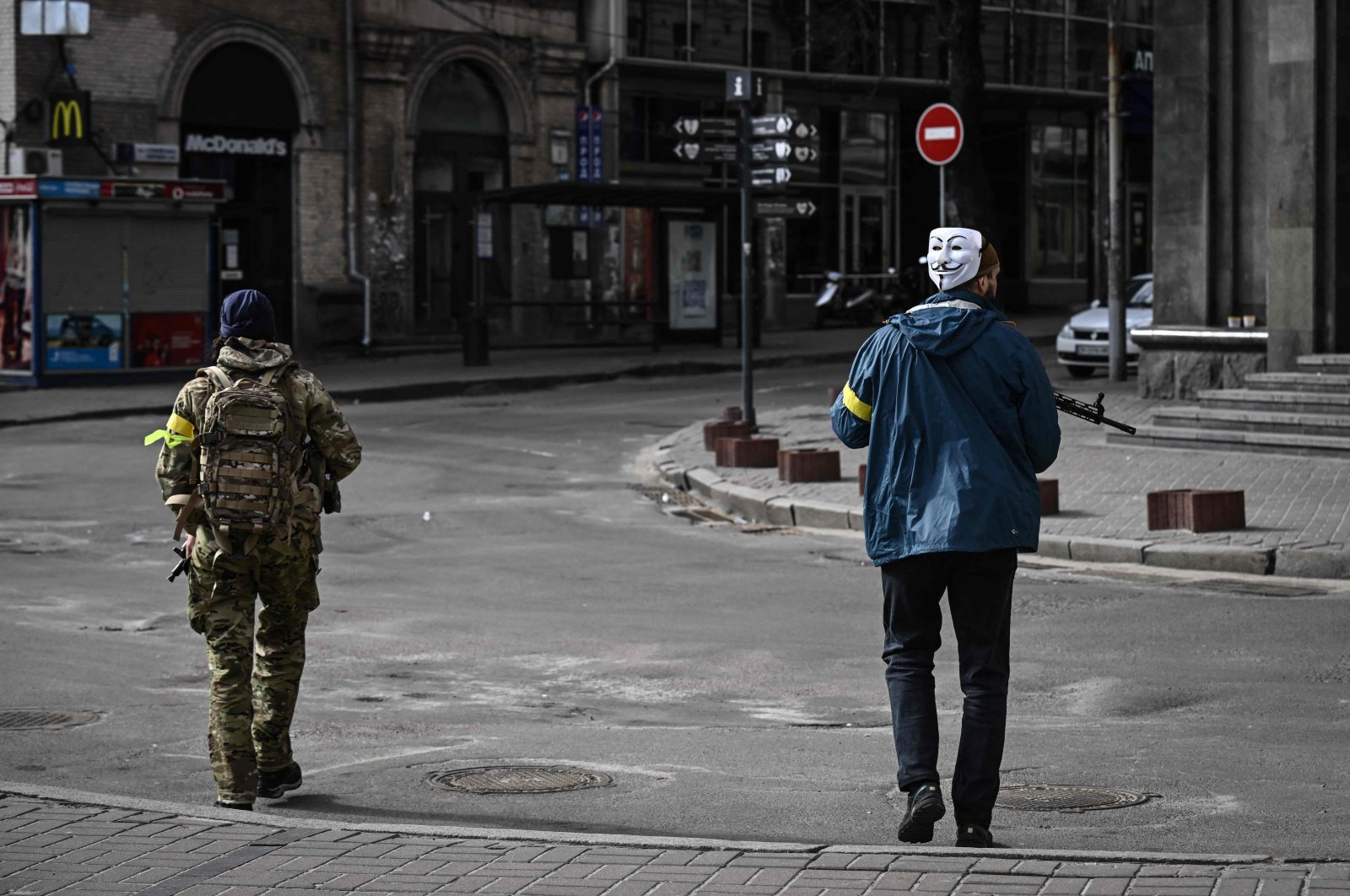 A member of Ukrainian forces, wearing Guy Fawkes mask (Anonymous mask), patrols downtown Kyiv, on Feb. 27, 2022. (Photo by Aris Messinis / AFP)