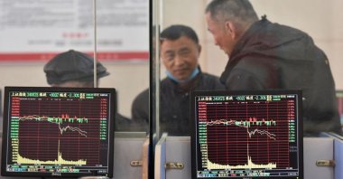 Investors are seen behind screens displaying stock information at a brokerage house in Fuyang, Anhui province, China, Feb. 24, 2022. (Reuters Photo)