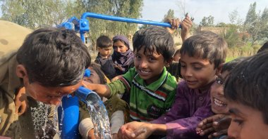 Children drink water from a well, in Muzaffargarh, Pakistan, Feb. 27, 2022. (AA PHOTO)