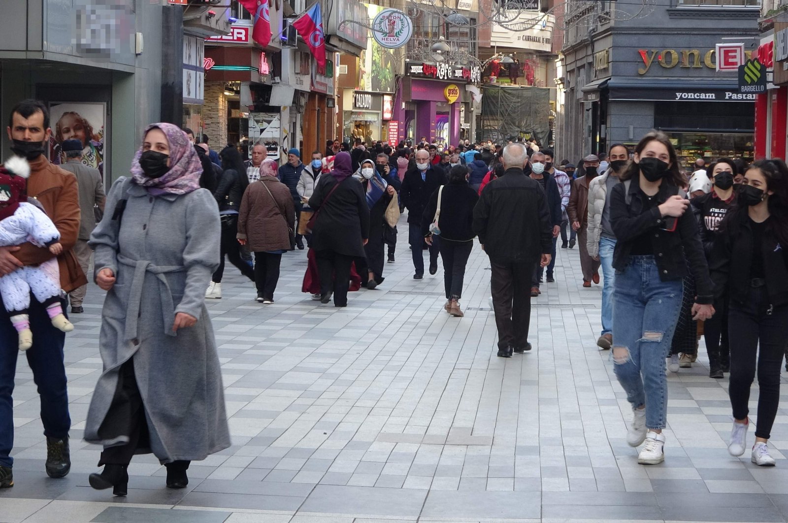 People wearing protective masks walk on a street in Trabzon, northern Turkey, Feb. 24, 2022. (IHA Photo)